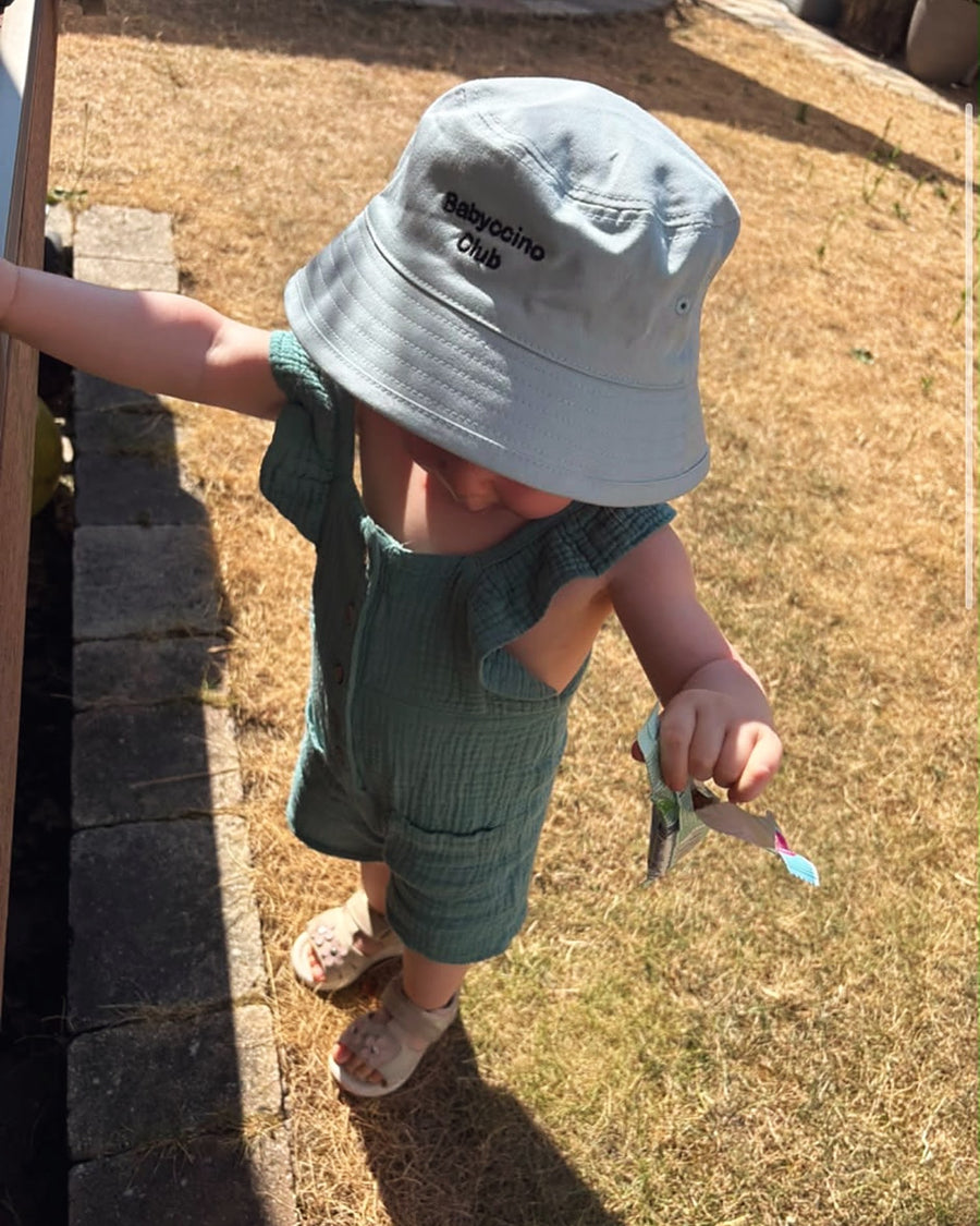 Babyccino Club bucket hat in the garden